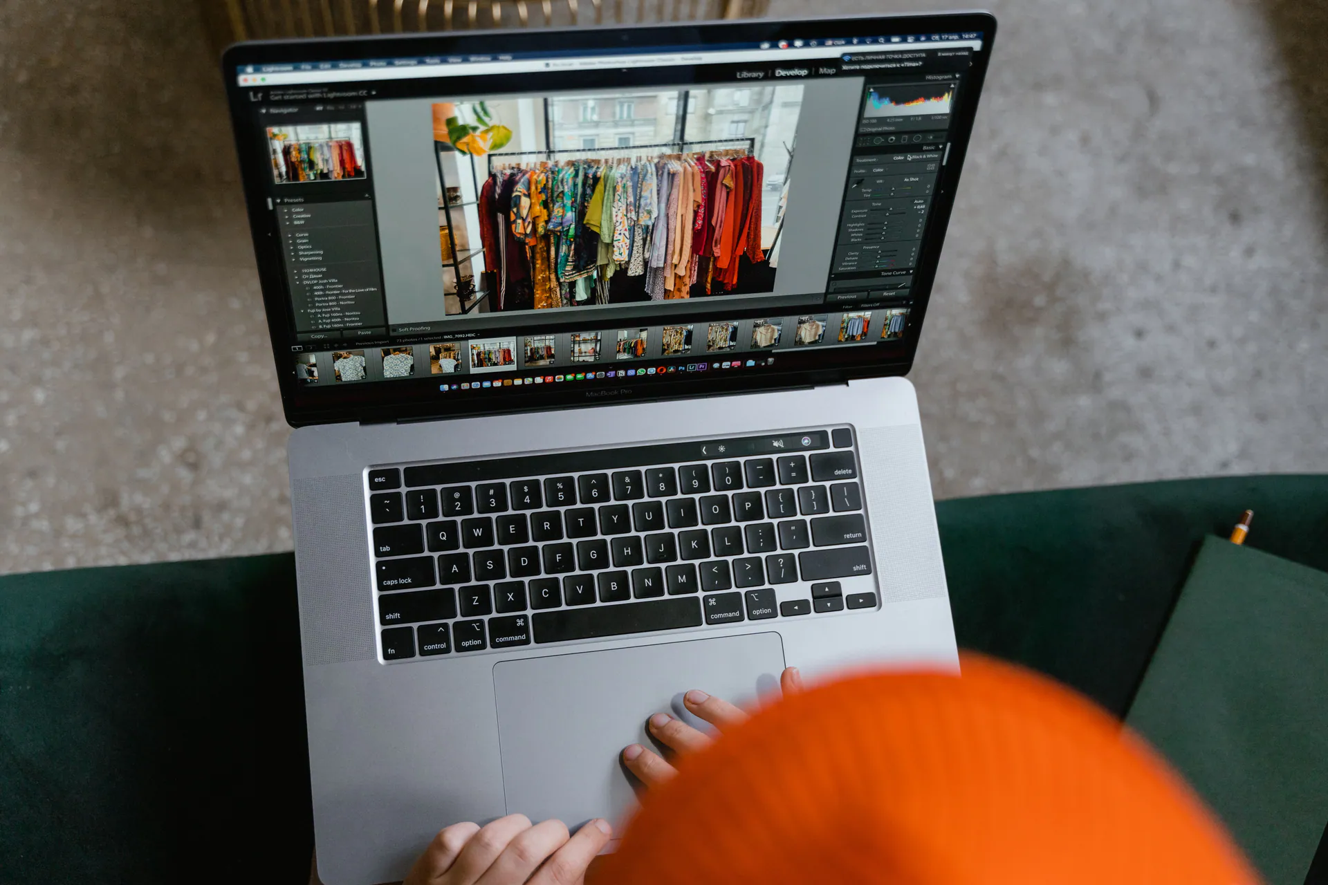 A laptop on a desk showing a photo editing application with a grid of clothing photos